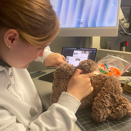 In this photo i'm cutting one of Miffy's paws open, the idea was to put a heart sensor in her paw. So when the user holds her paw, we can read their heartbeats on our screen.