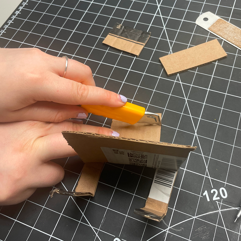 This is me randomly cutting out cardboard for our second phone stand. I had no real plan in mind other than messing around and finding out.